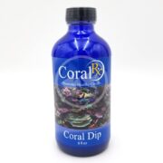 A blue bottle labeled CORAL RX DIP 8 OZ, promoting healthy corals, features an image of vibrant corals underwater.
