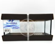 The SEAPORA 3 PLACE BETTA 1.5 GALLON is a sleek glass aquarium with black trim, featuring a blue fish graphic and Seapora label on the right. Its compact design and secure gray packaging make it perfect for your aquatic display needs.