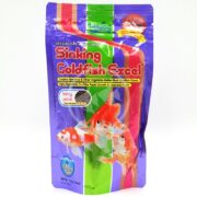 A 3.8 oz package of HIKARI Goldfish Excel Baby Sinking fish food, colored purple and pink with goldfish images, emphasizes spirulina and vegetables for rapid growth and desirable form.