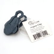 The AQUARIUM ESSENTIALS CLOWNFISH ALGAE CLIP, featuring a gray fish shape and durable suction cup, includes a white tag indicating its compatibility with clownfish tanks, long-lasting suction, and universal aquarium safety. Barcode and item number are listed.