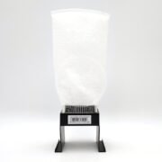 A clear plastic bag of white pellets stands upright on a black metal stand, resembling the FILTER SOCK SM FUSION 10 20 25. A barcode is visible near the base, set against a plain white background.