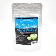 The GLAS GARTEN SHRIMP SNACKS SNOW FLAKES CHARD SPINACH 30 GM is a silver foil pack with snowflake designs, showcasing German text and highlighting its chard spinach content in a green circle.