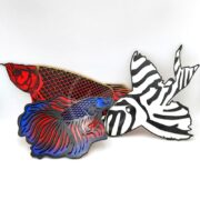 The DECORATIVE AQUARIUM FISH WALL ART features three fish-shaped plaques on a white background: one with red and black scales, another with blue and red fins, and a third with zebra-like stripes. This custom-carved piece adds aquatic charm to any space.