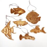 The DECORATIVE AQUARIUM FISH HANGING ORNAMENT features intricately carved wooden fish, such as angel fish, with detailed patterns on a white background, complete with strings for easy hanging as charming decorations.