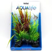 An aquarium display showcases the Aqualife Red Sagittarius Plant Mix 10 PP1700, with colorful artificial plants having long green and reddish leaves. The background features the AquaLife brand logo, fish illustrations, and a blue stand labeled deco scapes.