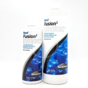 Two white bottles of SEACHEM REEF FUSION 1, featuring a blue coral design: a 16.9 fl oz bottle and a larger 1.06 QT bottle. Text highlights this two-part system for maintaining calcium and alkalinity in aquariums.
