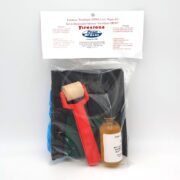 A Firestone PondGard EPDM liner repair kit in clear packaging, containing a red-handled roller, a small bottle of solution, a black patch, and repair instructions.