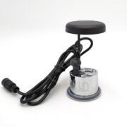 A small, metallic ultrasonic mist maker with a black circular top, attached to a power cord, is displayed against a plain white background.