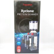A black box for the Aquatop Xyclone Protein Skimmer displays an image of the skimmer, product features, and capacity ratings of 100 gallons and 370 gallons. The background has a blue water splash and a fish silhouette.