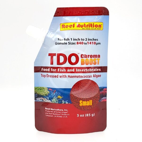 A red and silver pouch of TDO Chroma BOOST fish food by Reef Nutrition, labeled for small fish and invertebrates, with images of coral and text highlighting Haematococcus algae content.
