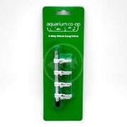 A packaged aquarium co-op 4 way metal gang valve is displayed on a green backing card, showing four adjustable metal valves aligned vertically for aquarium air line control.
