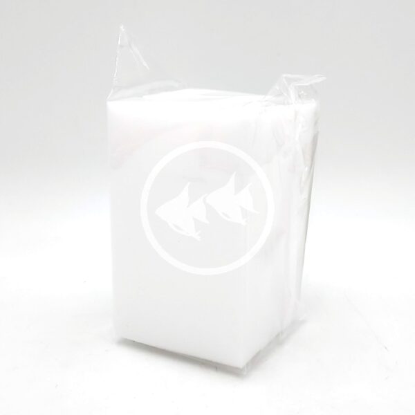 A rectangular white sponge wrapped in clear plastic packaging, standing upright on a plain white background.