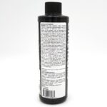 A black bottle with a white label displaying instructions and guidelines for use. The bottle has a ribbed black cap and text in small black font covering most of the label. The background is plain white.