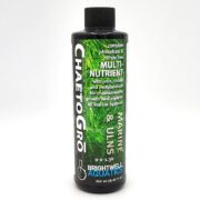 A black bottle of ChaetoGro by Brightwell Aquatics, labeled as a complete, phosphate and nitrate free multi-nutrient for marine and ULNS aquariums, shown with green aquatic plants in the background.