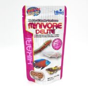 A pink and white package of Hikari Mini Algae Carnivore fish food, labeled MINIVORE DELITE, featuring images of various fish and text highlighting it as a balanced, color-enhancing diet with live food alternatives.