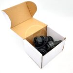 Open white cardboard box containing several black plastic hose or pipe connectors, displayed on a plain white background.