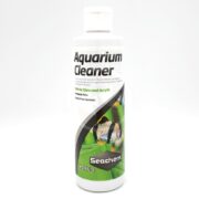 A white bottle labeled SEACHEM AQUARIUM CLEANER 250 ML (8.5 OZ) features Seachem branding, a fish image, and highlights that it’s safe for glass and acrylic, ammonia-free, and made with a streak-free formula.