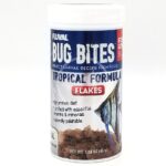 A 1.58 oz (45 g) container of FLUVAL BUG BITES TROPICAL FLAKES A7331, featuring a vibrant tropical fish and flakes. The label highlights high protein, essential vitamins/minerals, and natural palatability for healthy fish.
