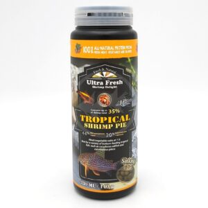 A cylindrical container of Ultra Fresh Tropical Shrimp Pie fish food, featuring images of tropical fish and shrimp on the label. The container highlights 100% natural protein and contains 140g (330ml) of sinking pellets.