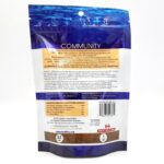 Back view of a blue and white bag of fish food labeled COMMUNITY, showing feeding instructions, ingredients, guaranteed analysis, barcode, and a Made in the USA logo at the bottom.
