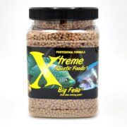 A clear plastic jar labeled “Xtreme Aquatic Foods Big Fella” containing brown fish food pellets. The black label features images of two colorful fish and bold yellow text.