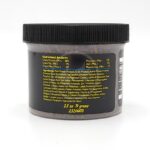 A plastic jar with a black lid displays a yellow label listing the guaranteed analysis, ingredients, and nutritional information for a pet food product. The text includes percentages for protein, fat, fiber, and moisture.