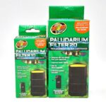 Two green boxes of Zoo Med Paludarium Filter replacement cartridges are shown: one labeled Filter 10 and the other Filter 20. Both highlight features like activated carbon and reusability.