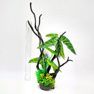 The PP DRIFTWOOD PLANT GREEN 15 DWP3, featuring green leaves and twisted black branches, stands next to a clear ruler for scale against a white background. The ruler indicates the plant is approximately 10 inches tall.