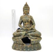 A PP RESIN SITTING BUDDHA RR680 statue with a weathered look and broken base, shown seated in meditation, is displayed in front of a clear ruler for scale on a white background.
