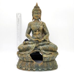 A PP RESIN SITTING BUDDHA RR680 statue with a weathered look and broken base, shown seated in meditation, is displayed in front of a clear ruler for scale on a white background.