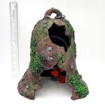 The PP RESIN SUNKEN GARDENS BELL by Penn Plax is a hollow artificial tree stump aquarium decoration with green moss, orange plants, and holes, shown next to a vertical ruler for scale against a white background.