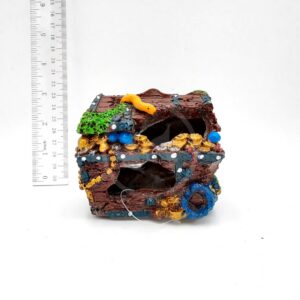 The PP RESIN TREASURE CHEST, a colorful decorative ornament, is shown beside a vertical ruler for scale, indicating it stands about 10 cm tall. The backdrop is plain white.