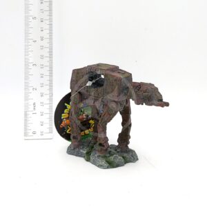 The UT RESIN SPACE BATTLE TANK SM sits on a rocky base next to a vertical ruler for scale, with a round tag in the background. The weathered model measures about 3 inches tall.