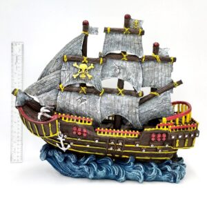 The PP RESIN PIRATE WAVE RUNNER RR963 features tattered gray sails, yellow skull and crossbones, red accents, and an anchor atop blue waves. A ruler stands beside the model pirate ship for scale.