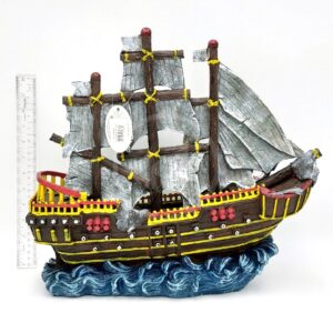 The PP RESIN PIRATE WAVE RUNNER RR963 is a decorative model ship with three masts, gray sails, and yellow-red accents on blue waves. A ruler beside it displays its size against a white background.