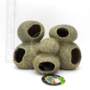 The UT RESIN MULTI STONE PLECO CAVE is a textured aquarium decoration with five stacked, hollow chambers. A white ruler beside it shows its scale, and a colorful tag is attached at the base, all set against a white background.