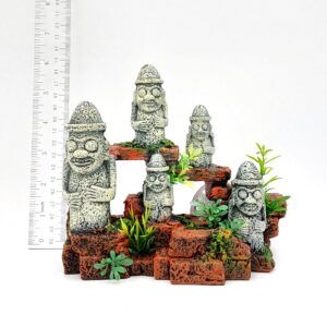 UT RESIN 5 STONE MEN features five small resin stone figures with hats and wide eyes, arranged on reddish-brown brick steps amid green plants. The tallest stands about 13 cm high, as shown by a ruler on the left. White background.