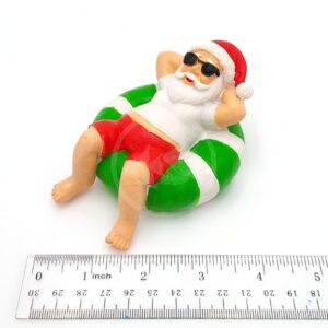 The PP RESIN HOLIDAY DECOR HOLR5B is a small Penn Plax figurine of Santa in sunglasses and red shorts lounging on a green and white pool float, measuring about 2 inches long.