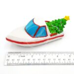 The PP RESIN HOLIDAY DECOR HOLR5B is a small white and red resin toy boat with a blue windshield and Christmas tree, measuring about 10 cm long—ideal for festive holiday decor.