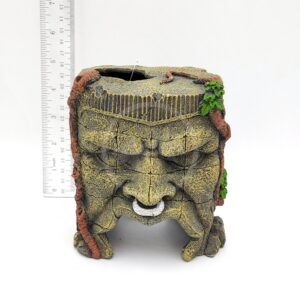 The UT RESIN MAYAN RUINS planter, shaped like an ancient Mayan face with a mustache, vines, and cracks, stands about 14 cm tall. Its stone-like design evokes underwater treasures or ruins against a white background.