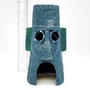 A blue, textured PP RESIN SQUIDWARD EASTER ISLAND HOME aquarium ornament with round eye holes and a large mouth opening is shown in front of a vertical ruler for scale.