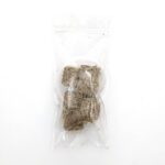 A clear plastic bag containing several small, brown, fibrous cubes is placed on a white background.