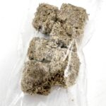 Six beige, fibrous rectangular blocks are packed together inside a transparent plastic bag on a white background. The blocks appear dry and textured, resembling compressed plant or fiber material.