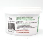 White plastic tub of specialty sinking pellet fish food with green and red text detailing feeding instructions, safety information, expiry date, barcode, and recycling symbol visible on the label.