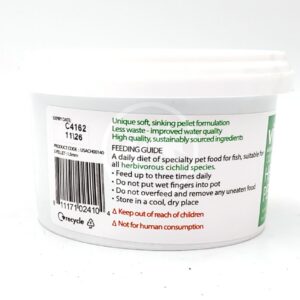 White plastic tub of specialty sinking pellet fish food with green and red text detailing feeding instructions, safety information, expiry date, barcode, and recycling symbol visible on the label.