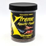 A container of XTREME SHRIMPEE SINKING STICKS with a black lid and colorful shrimp images contains 2.4mm sinking sticks, professionally formulated for aquarium shrimp.